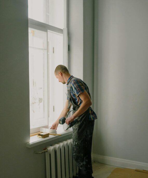 Man with screwdriver preparing for renovation in apartment